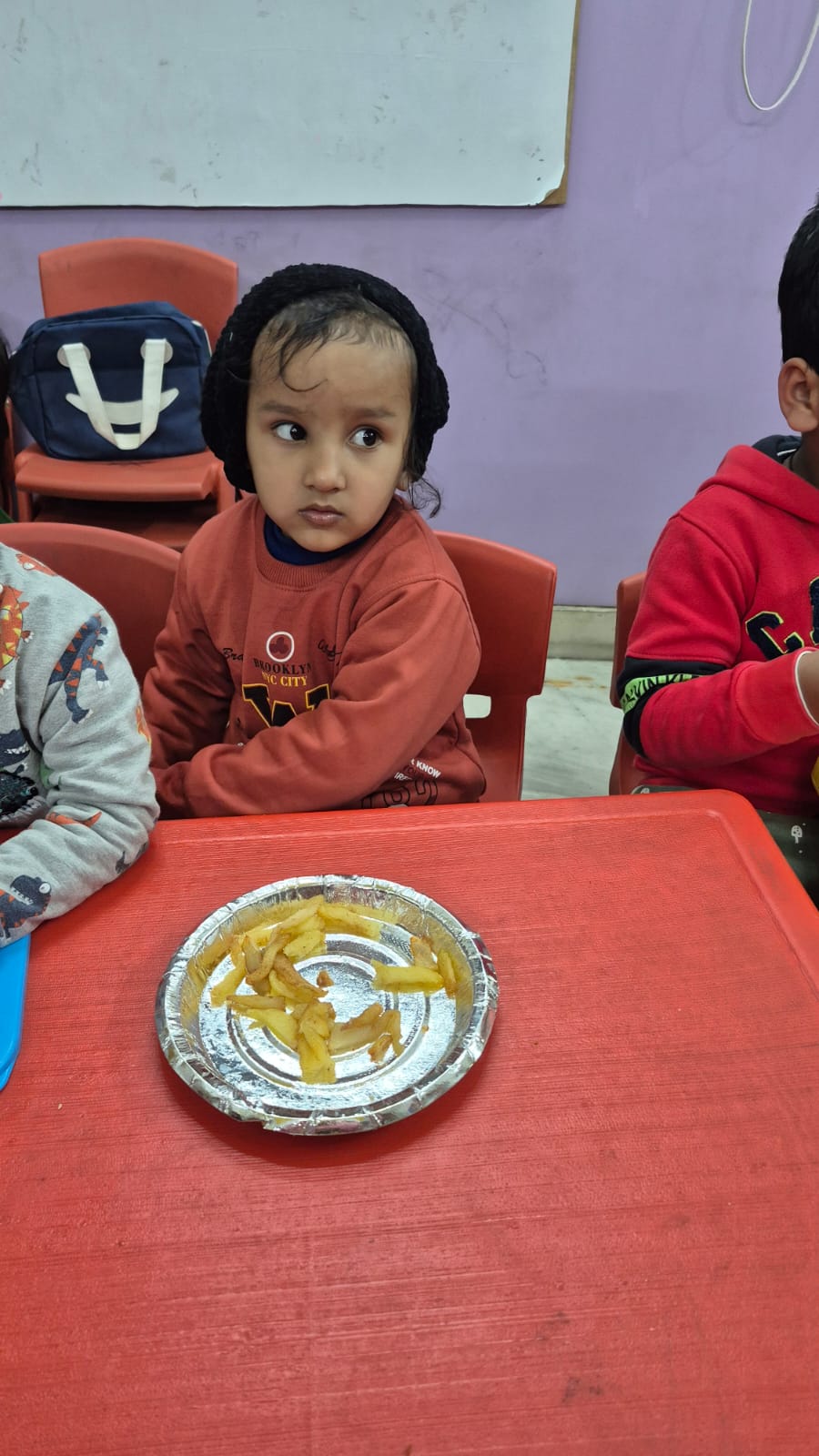 Children receiving meals around table